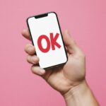 Primer plano de un teléfono con un ‘OK’ gigante, símbolo visual de la ambigüedad digital